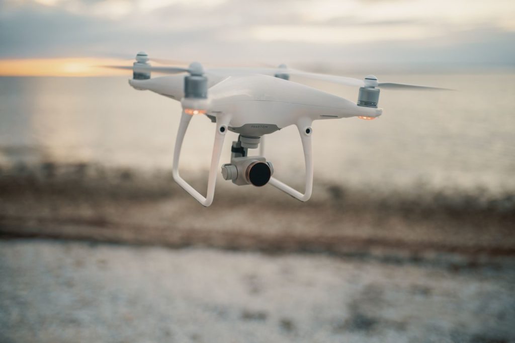 Een quadcopter boven een kustlandschap bij avondlicht
